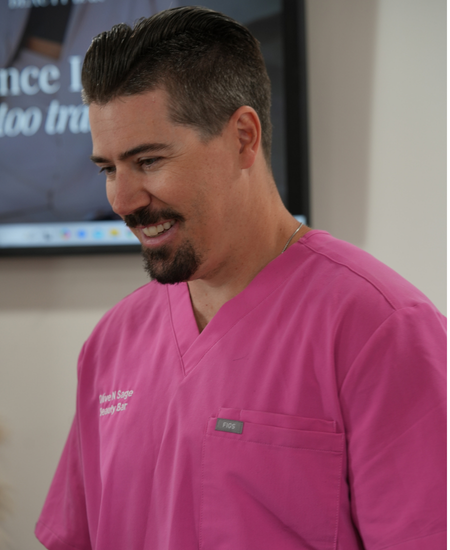 Student practicing camouflage tattooing on live model